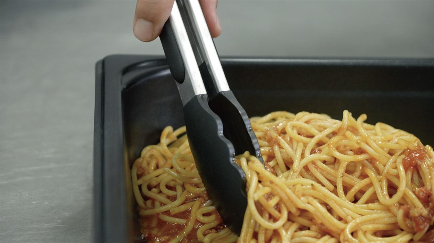 Cooking tongs lifting spaghetti
